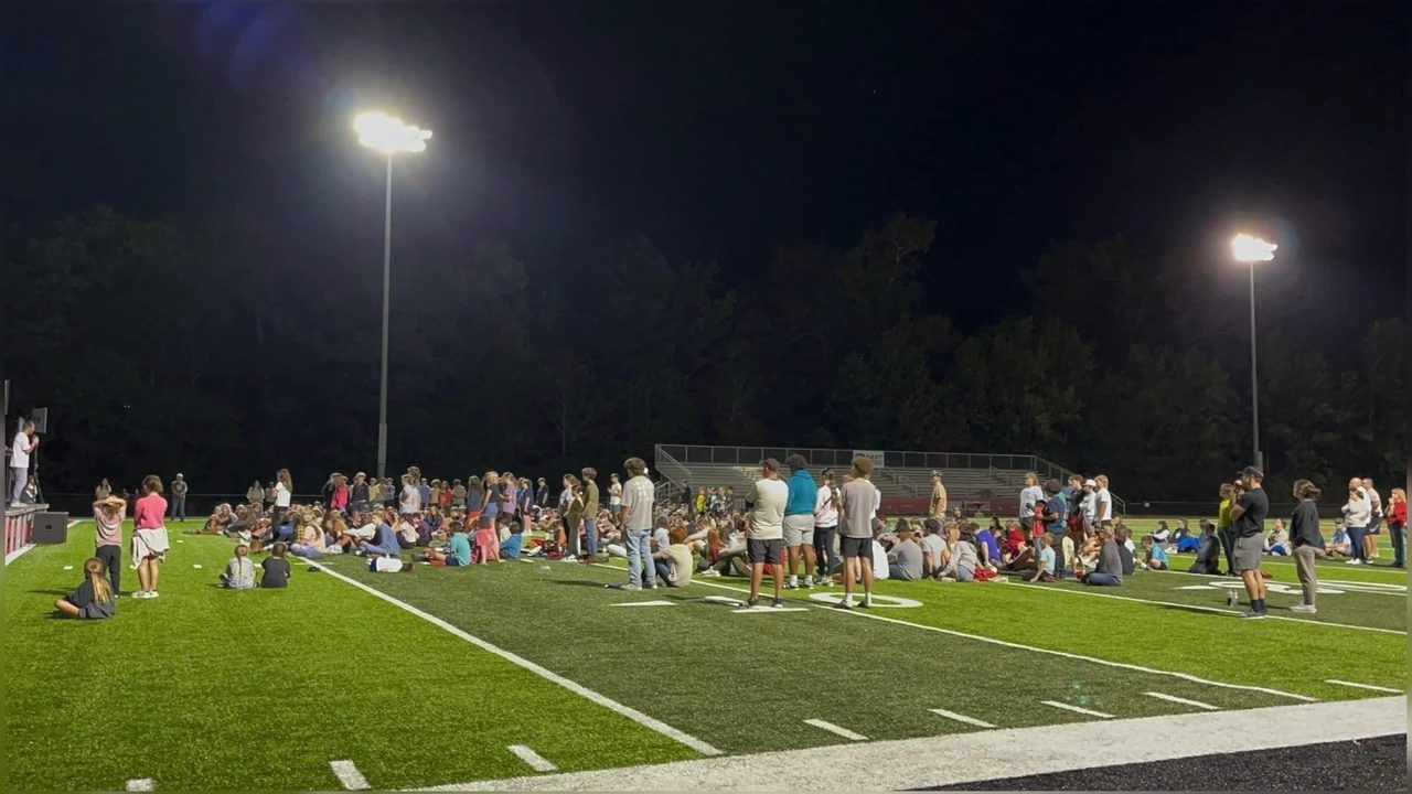 Students and coaches gathered on the field under the lights at a Saline River FCA Fields of Faith night in Saline County, Arkansas