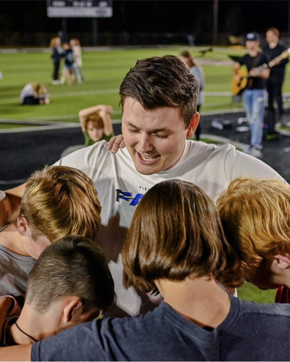 Saline River FCA coaches and athletes praying together in Arkansas